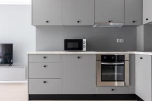 a kitchen with white cabinets and a microwave at Tower Apartments in Cluj-Napoca