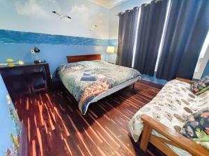 una camera con due letti in una stanza con pareti blu di The Pirate Haus Inn a St. Augustine