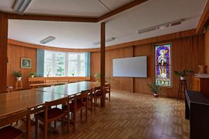 a conference room with a large table and a stained glass window at Birgittagården in Falun