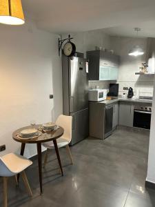 a small kitchen with a table and chairs and a table and a table and chairs at Apartamento ROSA in Valle de Abdalagís