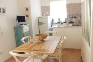 a kitchen with a wooden table and chairs in a kitchen at Fiordilavanda in Martina Franca