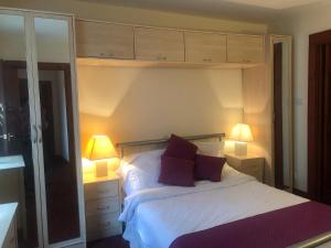 a bedroom with a white bed with two lamps at Executive Serviced apartments 2 in Forfar