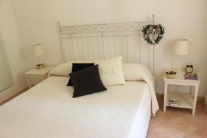 マルティナ・フランカにあるFiordilavandaのベッドルーム1室(白い大型ベッド1台、テーブル2台付)