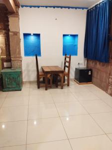 a room with a table and two chairs and a television at Geel Heritage - A Restored Haveli in Jodhpur