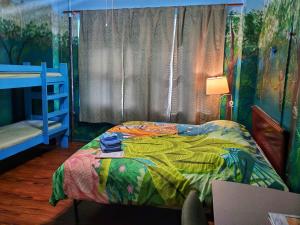 a bedroom with a bed with a colorful comforter at The Pirate Haus Inn in St. Augustine