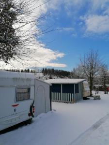 an rv parked in the snow in front of a house at Campingplatz Am Bärenbache in Braunlage