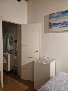 biały pokój z łóżkiem i komodą w obiekcie Habitaciones boutiques w mieście Algeciras