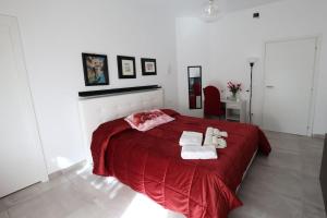 um quarto com uma cama vermelha e 2 toalhas em B&B Royal Palace of Napoli & Reggia di Caserta em Caserta