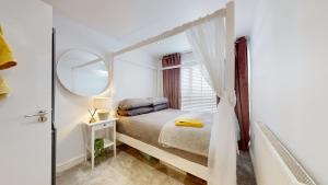 een witte slaapkamer met een bed en een spiegel bij Modern Cardiff City Apartment in Cardiff