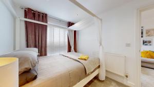 een slaapkamer met een bed en een raam bij Modern Cardiff City Apartment in Cardiff