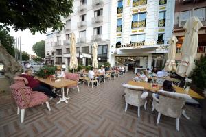 a group of people sitting at tables outside a building at Babel Park Hotel in Istanbul
