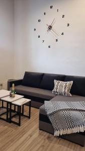 a living room with a couch and a clock on the wall at Apartmán Kompas in Spišské Podhradie