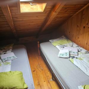 two beds in a room with a wooden ceiling at Restoran Domaćin in Bosanski Novi