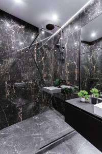 a black bathroom with two sinks and a shower at Great View Apartment in historical city center in Kyiv