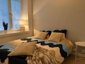 a bedroom with a bed with pillows and a window at Citylux Verdandi in Turku