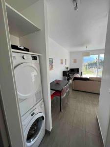 a washing machine in a room with a living room at Au Cœur du Vignoble Valaisan in Saint-Léonard