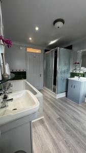 a bathroom with a white sink and a mirror at The Railway Sleeper Lodge in Colchester