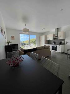 cocina y sala de estar con mesa y sillas en Au Cœur du Vignoble Valaisan, en Saint-Léonard