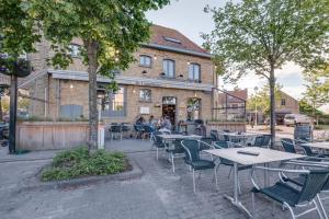 a group of tables and chairs in front of a building at De Lanterfanters Vakantiehuisjes in Nieuwpoort