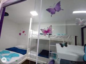 a room with a bunk bed with butterflies on the wall at Chalé 1 Container Ubatuba Ruínas da Lagoinha Praia da Lagoinha in Ubatuba