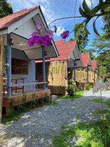 a row of cottages with purple flowers at KANNIKA RESORT in Ko Chang