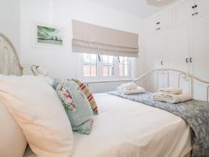 a white bedroom with two beds with pillows at Holmleigh, Aldeburgh in Aldeburgh