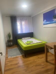 - une petite chambre avec un lit vert dans l'établissement Apartment am Schlosspark 3, à Egra
