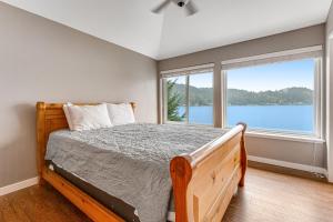 1 dormitorio con cama y ventana grande en Summit Lake Getaway, en Kamilche