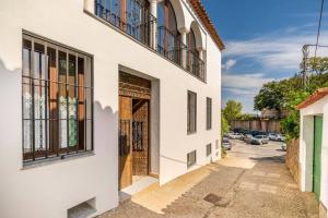 un edificio blanco con una puerta y una calle en Casa Sierraverde Fuenteheridos by MSHOLIDAYS, en Fuenteheridos