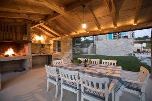 a patio with a table and chairs and a fireplace at Villa Kanedolo in Momjan