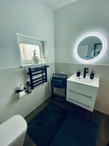 een badkamer met een witte wastafel en een spiegel bij Ferienwohnung Niederlaasphe in Bad Laasphe