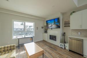 a living room with a fireplace and a tv at Skyline Peaks 205 - Mountain View Townhouse-AC-Pool-Hot Tub in Canmore