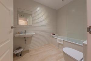 Baño blanco con lavabo y aseo en Hotel Casa Jurjo en Mazaricos