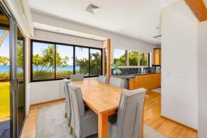 a kitchen and dining room with a wooden table and chairs at South Shore Paradise - 30-Night Minimum in Honolulu