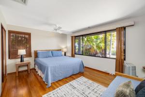 a bedroom with a bed and a large window at South Shore Paradise - 30-Night Minimum in Honolulu