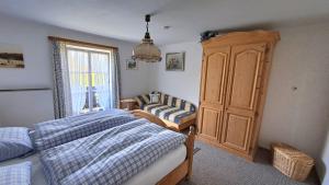 a bedroom with a bed and a cabinet and a window at Bauernhaus Jocher in Krün