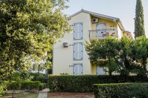 a white house with a balcony and trees at Apartments Villa Borik in Rovinj