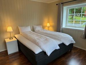 a bed in a bedroom with two lamps and a window at Aurlandsfjord Panorama in Aurland