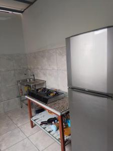 a kitchen with a stove and a refrigerator at POSADA SALAS & KARI PERU TRAVEL in Mollendo