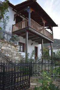 a house with a balcony on top of a fence at Lila's Guest House in Mikrós Prínos