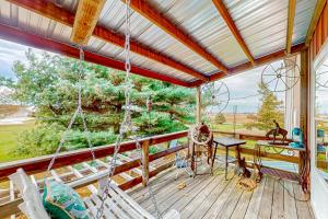 a porch with a hammock and a swing at Red Barn Retreat 