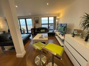 a living room with a couch and a table at Ultra Luxury Beach Penthouse in Holland-on-Sea