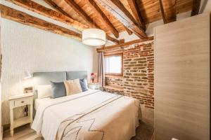 een slaapkamer met een bed en een bakstenen muur bij Apartamento Plaza de España 2 in Madrid