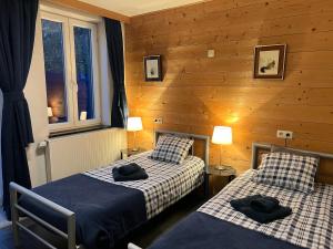 two beds in a room with wooden walls at Dame Cerise in Wavre +76 photos