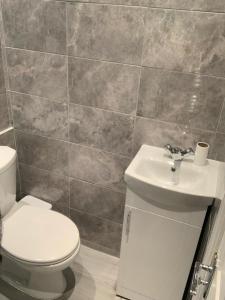 a bathroom with a toilet and a sink at Luxury Living Manchester in Manchester