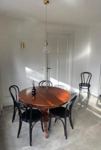 een houten tafel en stoelen in een kamer bij Stijlvol ruim studio-appartement nabij historisch centrum in Amersfoort