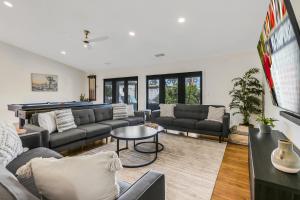 a living room with couches and a pool table at THE Fun House FULL Arcade LUX backyard Sleeps 12 in Indio