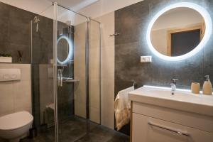 a bathroom with a shower and a sink and a mirror at Apartmany ROSTER in Liptovský Mikuláš +25 photos