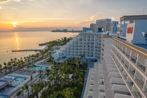 カンクンにあるRiu Caribe - All Inclusiveの夕日の海とホテルの空中を望む