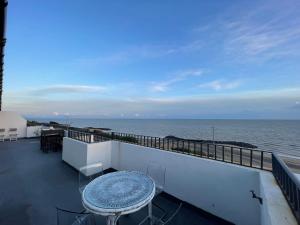 een balkon met een tafel en uitzicht op de oceaan bij Ultra Luxury Beach Penthouse in Little Holland